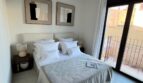 Helles Schlafzimmer mit Doppelbett, abstrakten Wandbildern und Balkonzugang in Luxus-Apartment, Palma de Mallorca