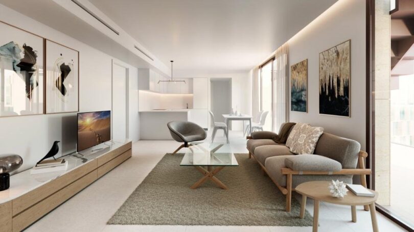 Helles Wohnzimmer mit modernem Sofa, Glasstisch, TV-Möbel und offenem Küchenbereich im Luxus-Apartment Palma