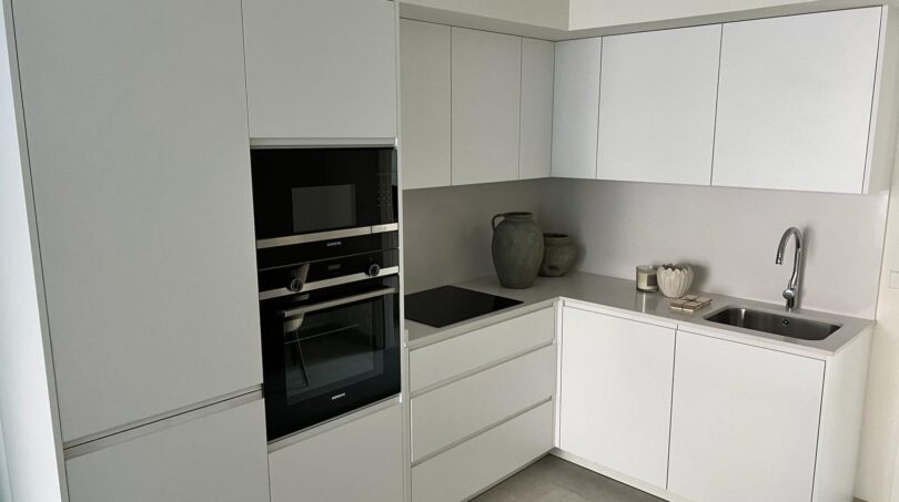 Modernes weißes Designküche mit Siemens-Einbaugeräten, Induktionskochfeld und Spüle in Luxusapartment Palma