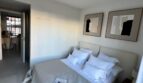 Elegantes Schlafzimmer mit Doppelbett, neutralen Tönen und modernen Kunstwerken im Luxusapartment Palma
