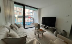 Helles Wohnzimmer mit Sofa, Flachbildschirm und Balkon mit Stadtblick im Luxusapartment Palma