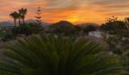 Espectacular puesta de sol sobre Santa Ponça con palmeras, villas y montañas – vista panorámica de la villa moderna.