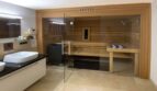 Baño de lujo de la villa en Santa Ponça con sauna de madera integrada, frente de cristal y elegantes baldosas de mármol.