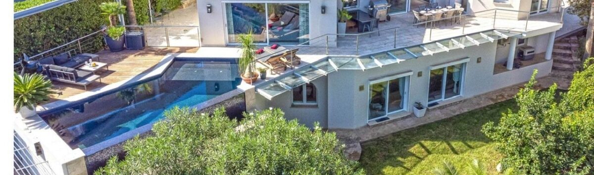 Vista aérea de villa moderna en Santa Ponça con piscina infinita, terraza de sol y jardín mediterráneo.