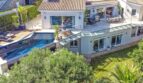 Vista aérea de villa moderna en Santa Ponça con piscina infinita, terraza de sol y jardín mediterráneo.