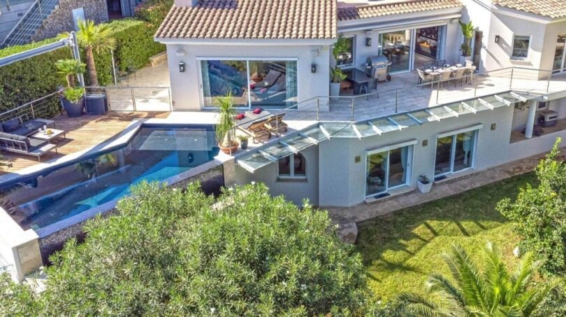 Vista aérea de villa moderna en Santa Ponça con piscina infinita, terraza de sol y jardín mediterráneo.