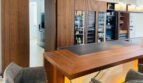 Moderna cocina-salón de la villa en Santa Ponça con barra de madera, barra iluminada y elegantes armarios para vino.