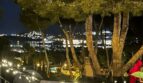Balcón iluminado por la noche con vistas panorámicas a las luces de Santa Ponça y la costa marina.