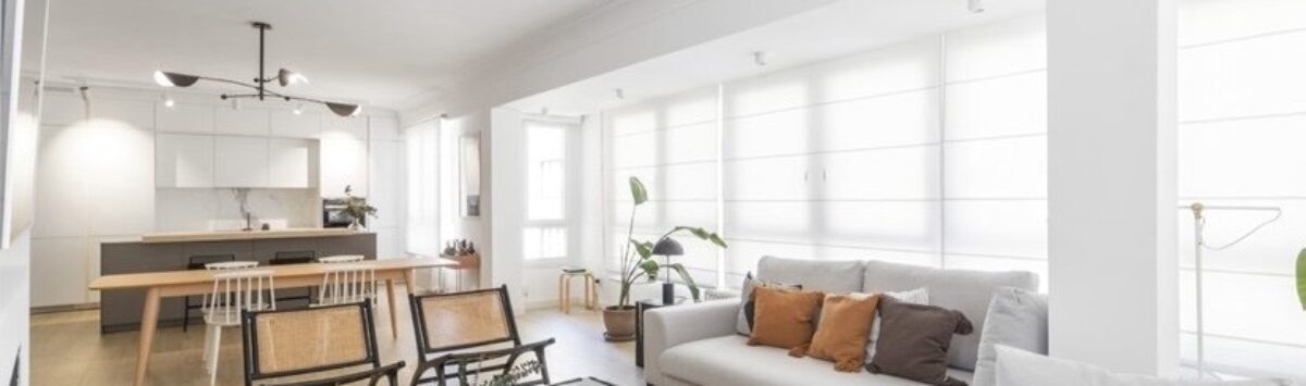 Helles Wohnzimmer mit grauem Sofa, Marmor-Couchtisch und offener Küche in modernisierter Palma-Wohnung.