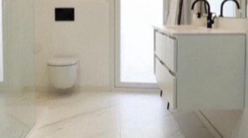 Modernes weißes Badezimmer mit Marmoroptik-Fliesen, schwebendem Waschtisch und wandhängendem WC in Palma-Wohnung.