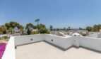 Helle Dachterrasse der Traumvilla in Sol de Mallorca mit Meerblick, Palmen und weißen Nachbarhäusern.