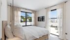 Helles Schlafzimmer der Traumvilla mit Doppelbett, Meerblick-Terrasse und eleganten Leinengardinen