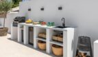 Moderne Außenküche der Traumvilla mit Grill, Spüle, Weidenkorb-Stauraum und mediterranem Flair.