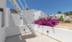 Sonnige Dachterrasse der Traumvilla in Sol de Mallorca mit weißer Treppe und blühender Bougainvillea