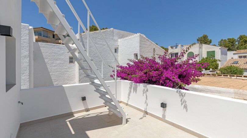Sonnige Dachterrasse der Traumvilla in Sol de Mallorca mit weißer Treppe und blühender Bougainvillea