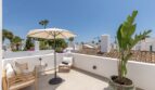 Sonnige Dachterrasse der Villa in Sol de Mallorca mit Loungemöbeln, Sonnenschirm und Palmen