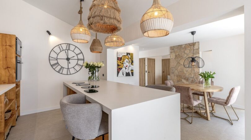 Offene Küche mit Kochinsel, Rattanlampen und Essbereich der Traumvilla in Sol de Mallorca