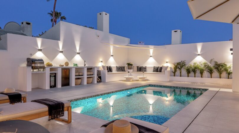 Beleuchteter Außenpool der Traumvilla in Sol de Mallorca bei Nacht mit Loungebereich und Outdoorküche