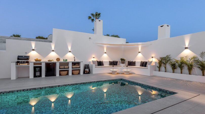 Beleuchteter Außenpool mit Loungebereich und Outdoorküche der Traumvilla in Sol de Mallorca bei Dämmerung