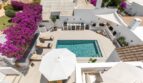 Luftaufnahme: Pool mit Sonnenliegen, Außenküche und Bougainvillea-Blüten der Villa in Sol de Mallorca