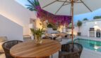 Traumvilla Sol de Mallorca: Elegante Terrasse mit Pool, Loungebereich und blühender Bougainvillea bei Abenddämmerung.