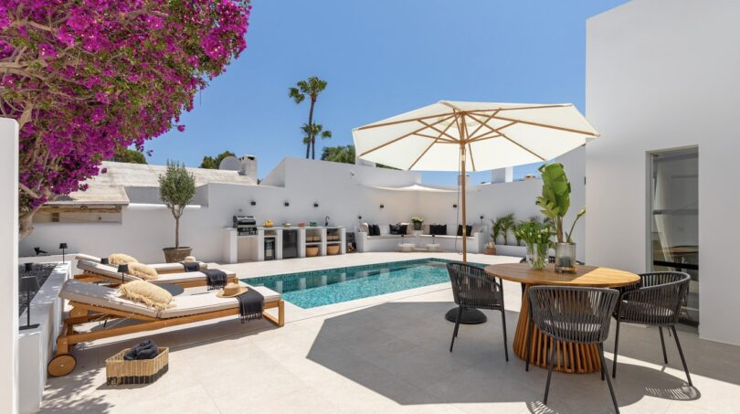 Sonnige Poolterrasse der Traumvilla in Sol de Mallorca mit Loungebereich, Außenküche und Bougainvillea