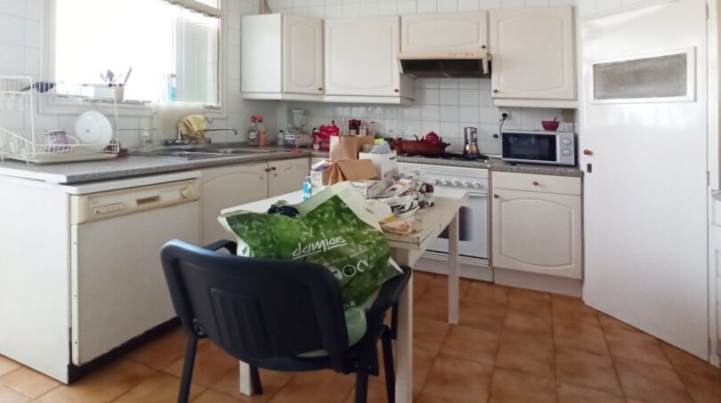 Geräumige, helle Küche mit weißen Einbauschränken, Fliesenboden und Renovierungspotenzial in Palma
