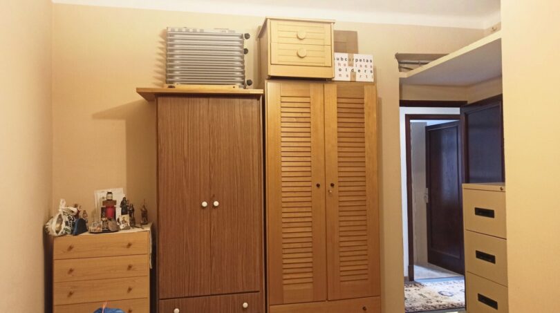 Schlafzimmer mit mehreren Holzschränken und Kommode, Durchgang zum Flur, Renovierungspotenzial in Palma