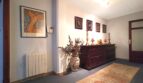 Eleganter Flur mit antikem Sideboard, Orientteppich, Kunstgemälden und dekorativer Vase in Palma-Wohnung.