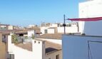 Dachterrassen-Ausblick auf weiße Altstadt-Gebäude mit Ziegeldächern unter blauem Himmel in Palma de Mallorca