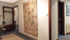 Heller Flur mit orientalischem Wandteppich, Läufer und dunklen Holztüren in Wohnung in Palma.