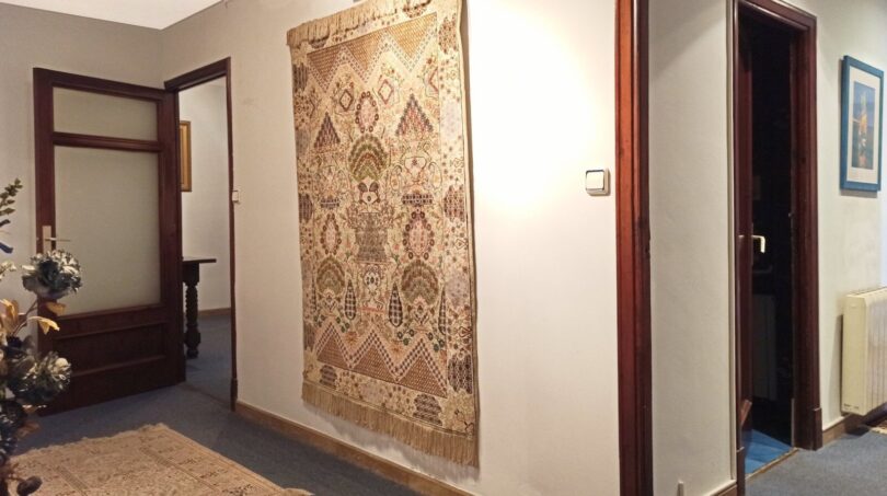 Heller Flur mit orientalischem Wandteppich, Läufer und dunklen Holztüren in Wohnung in Palma.