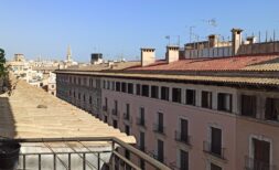 Dachterrasse mit Wäscheleine und Blick auf historische Altstadt von Palma de Mallorca bei blauem Himmel.