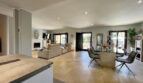 Offener Wohn- und Essbereich mit Designermöbeln, Kamin und großen Fenstern im exklusiven Einfamilienhaus in Llucmajor.
