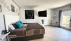 Helles Schlafzimmer mit Doppelbett, türkisen Kissen, Wandkunst, TV und Terrassenzugang in Llucmajor