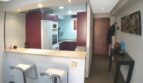 Offene Küche mit lila Fronten, Marmor-Theke und zwei Barhockern in exklusiver Wohnung in Port Adriano