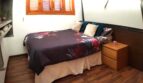 Schlafzimmer mit Doppelbett, Holzparkett und Holzjalousien in exklusiver Wohnung am Yachthafen Port Adriano