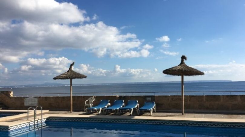 Außenpool mit Meerblick, Sonnenliegen und Strohdach-Sonnenschirmen der Luxuswohnung in Illetas