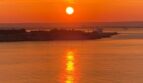 Spektakulärer Meerblick bei Sonnenuntergang mit orangenem Himmel, Wasserreflexion und Küstensilhouette in Illetas, Mallorca.
