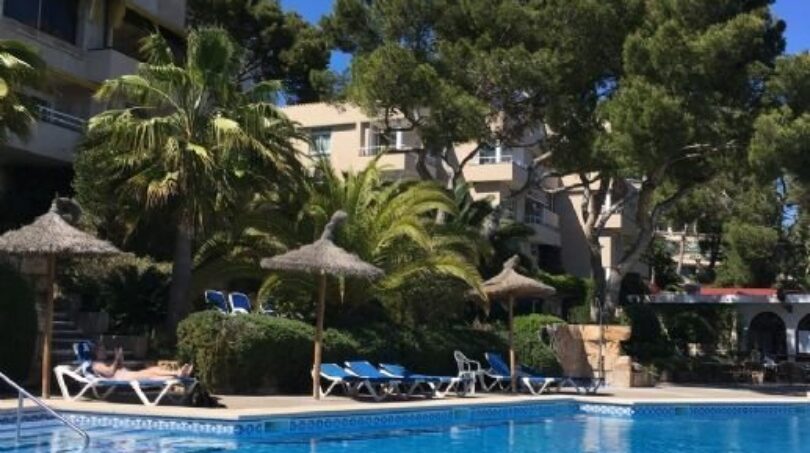 Luxuriöser Außenpool mit Liegestühlen, Palmen und mediterraner Hotelanlage in Illetas, Mallorca.