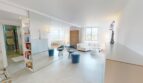 Helles Wohnzimmer mit Spiegelwand, blauen Hockern, weißem Sofa und Meerblick in Luxuswohnung Illetas