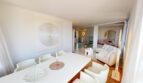 Helles Wohn-Esszimmer mit weißen Möbeln, Kunstwerk und Blick in weitere Räume der Luxuswohnung in Illetas