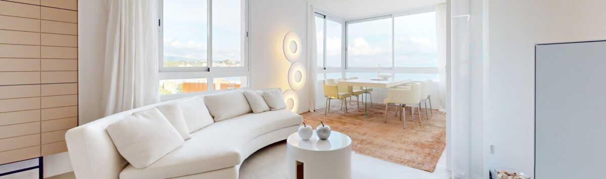 Helles Wohnzimmer mit weißem Curved-Sofa, Panoramafenster und Meerblick in exklusiver Luxuswohnung in Illetas