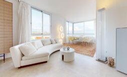 Helles Wohnzimmer mit weißem Curved-Sofa, Panoramafenster und Meerblick in exklusiver Luxuswohnung in Illetas