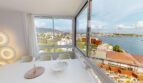 Helles Esszimmer mit Panoramafenster und Meerblick auf Illetas, weiße Möbel, moderne Wandlampen