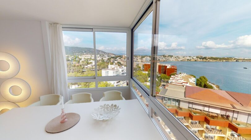 Helles Esszimmer mit Panoramafenster und Meerblick auf Illetas, weiße Möbel, moderne Wandlampen