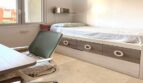 Kinderzimmer mit Einzelbett mit Schubladen, Schreibtisch und Fenster im Reihenhaus Llucmajor