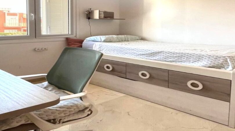 Kinderzimmer mit Einzelbett mit Schubladen, Schreibtisch und Fenster im Reihenhaus Llucmajor