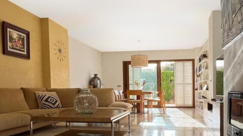 Helles Wohnzimmer mit Marmorböden, Ecksofa und Essbereich mit Gartenausblick im Reihenhaus Llucmajor