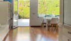 Helles Wohnzimmer mit Holzboden, Terrassenzugang und Gartenblick im modernen Reihenhaus in Llucmajor.